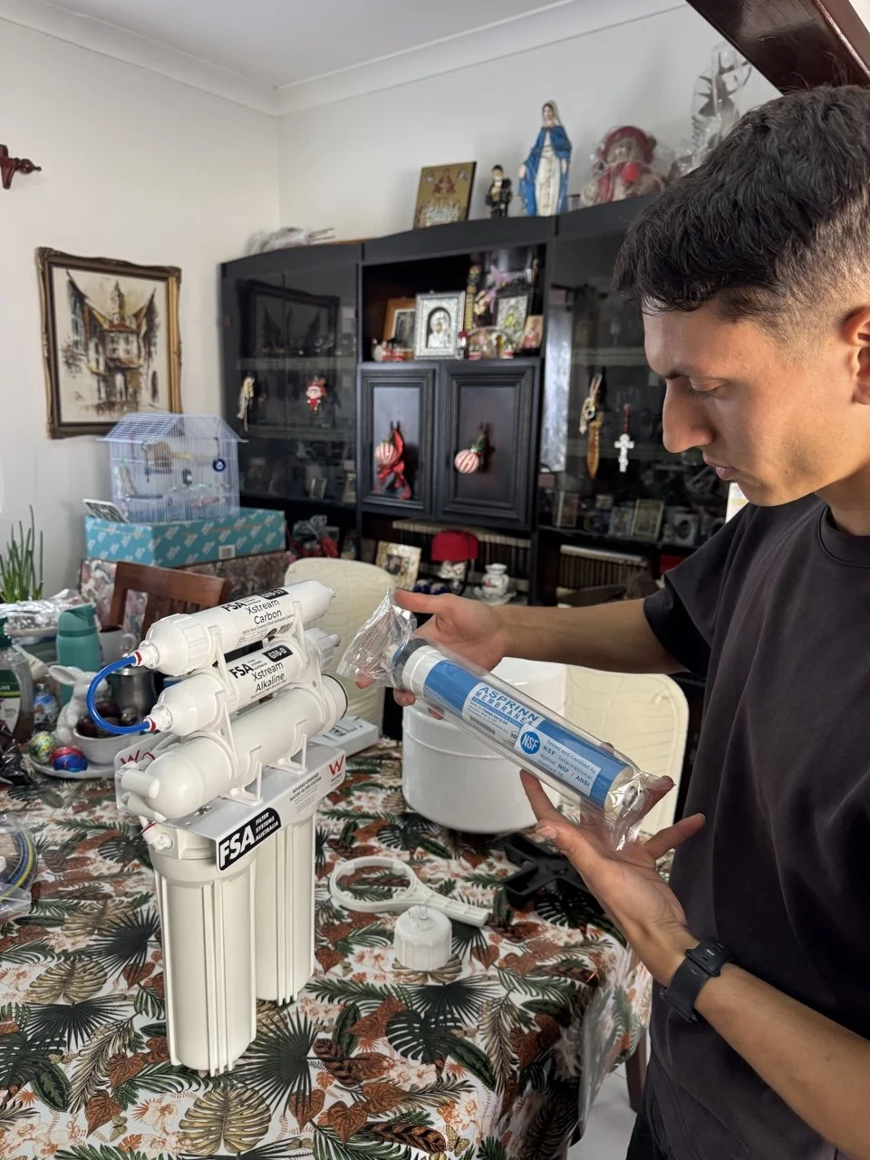 Licensed plumber completing under-sink water filter installation