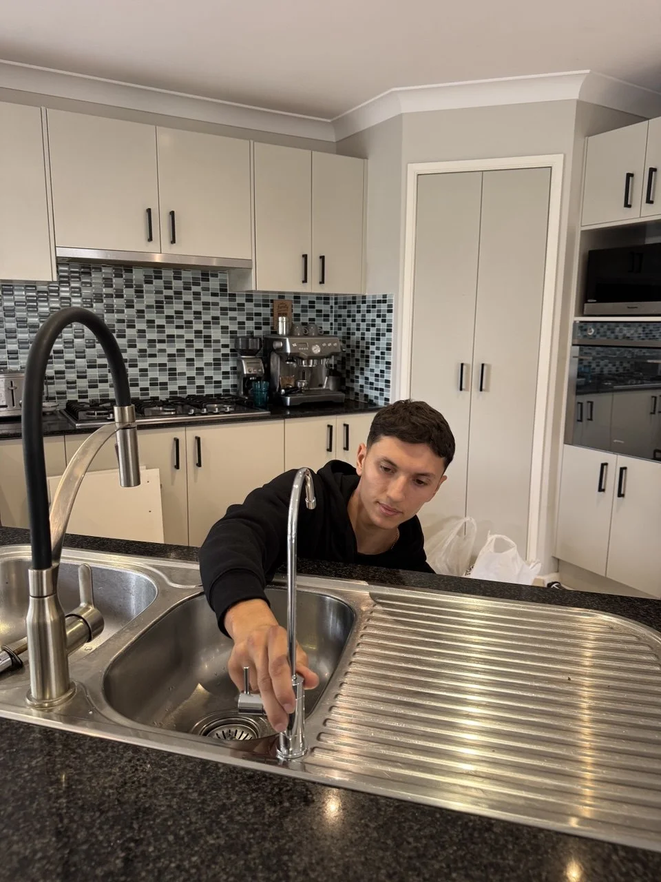 Jean-Paul connecting RO drain and supply lines under sink Sydney