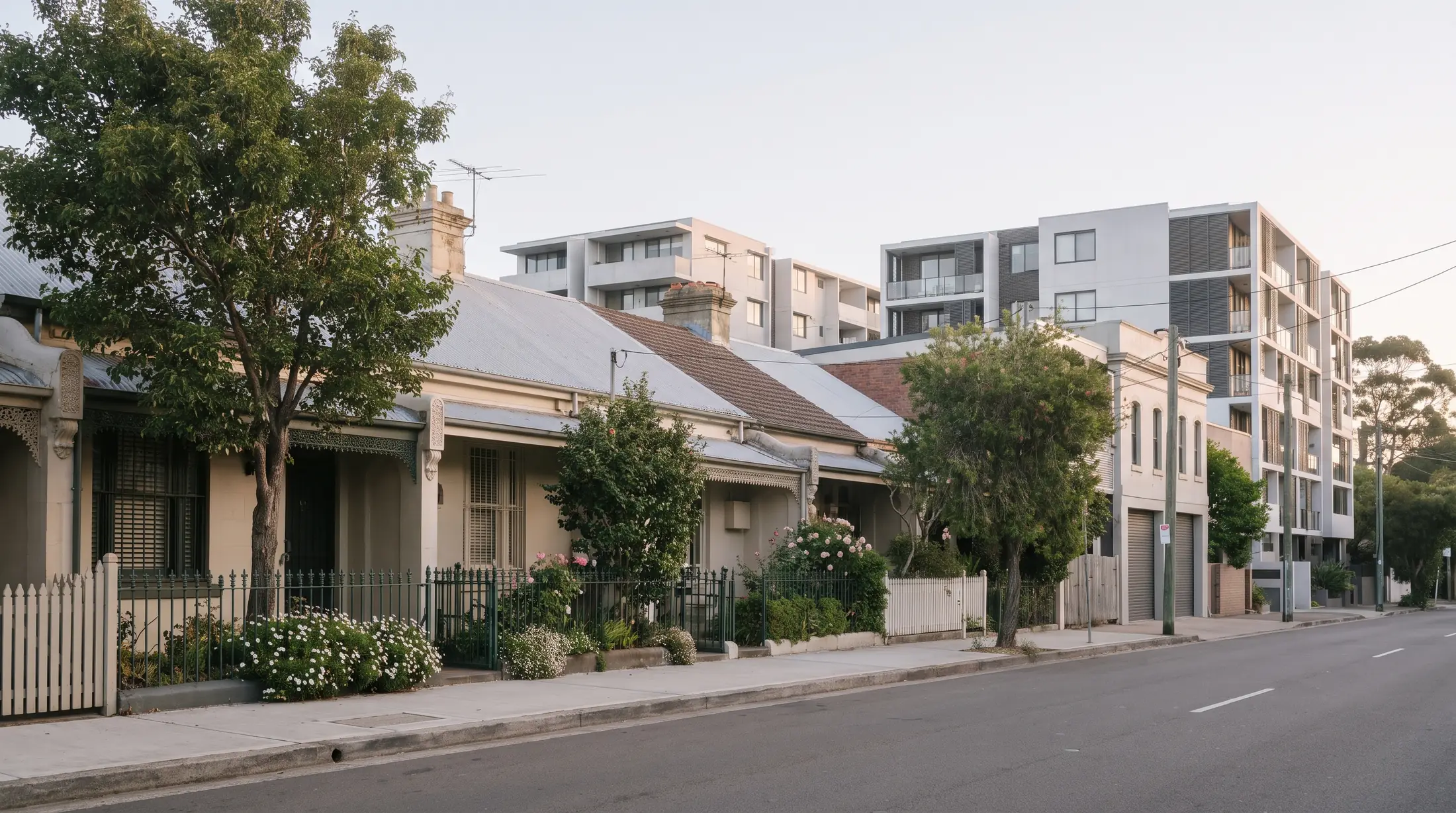 Small cottages and narrow terraces on a leafy Erskineville street, illustrative residential scene