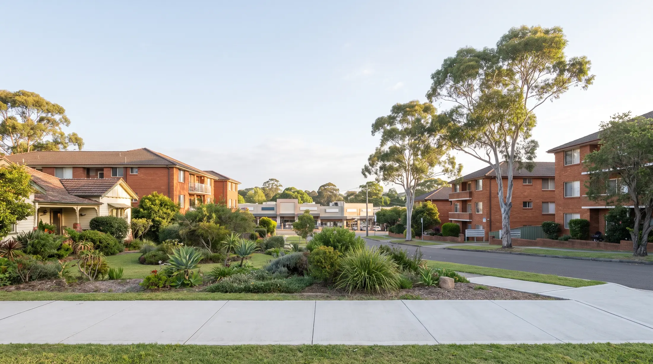 Apartment buildings and established gardens along a Hillsdale residential street, illustrative residential scene