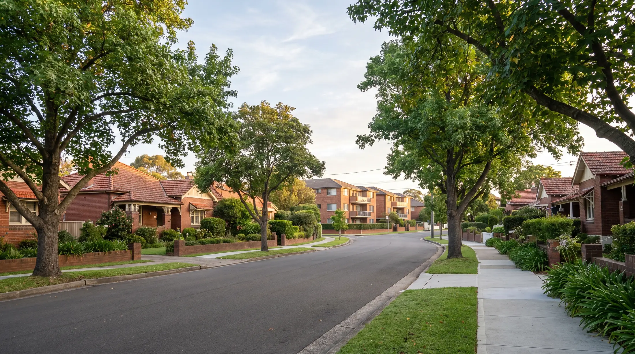 Historic brick homes and newer apartments along a leafy Homebush residential road, illustrative residential scene