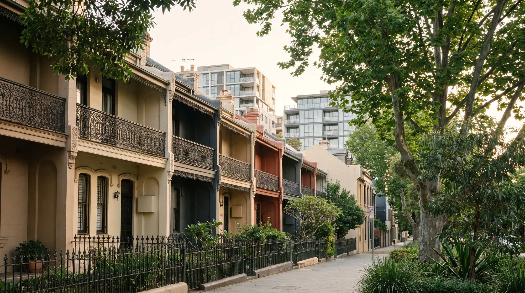 Victorian terraces with newer apartments beyond a leafy Redfern street, illustrative residential scene