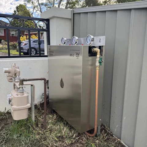 A whole house unit installed against a Colorbond fence