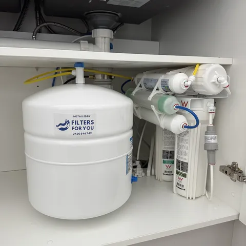 A Filters For You reverse osmosis system installed inside a white kitchen cabinet