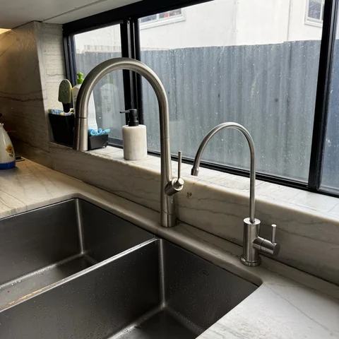 The dedicated filtered water tap on a stone benchtop