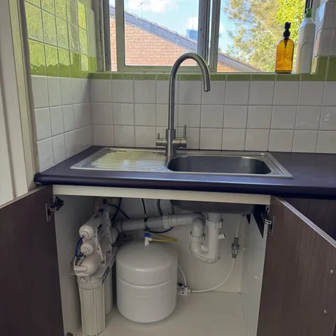 A finished under sink install with the cabinet open